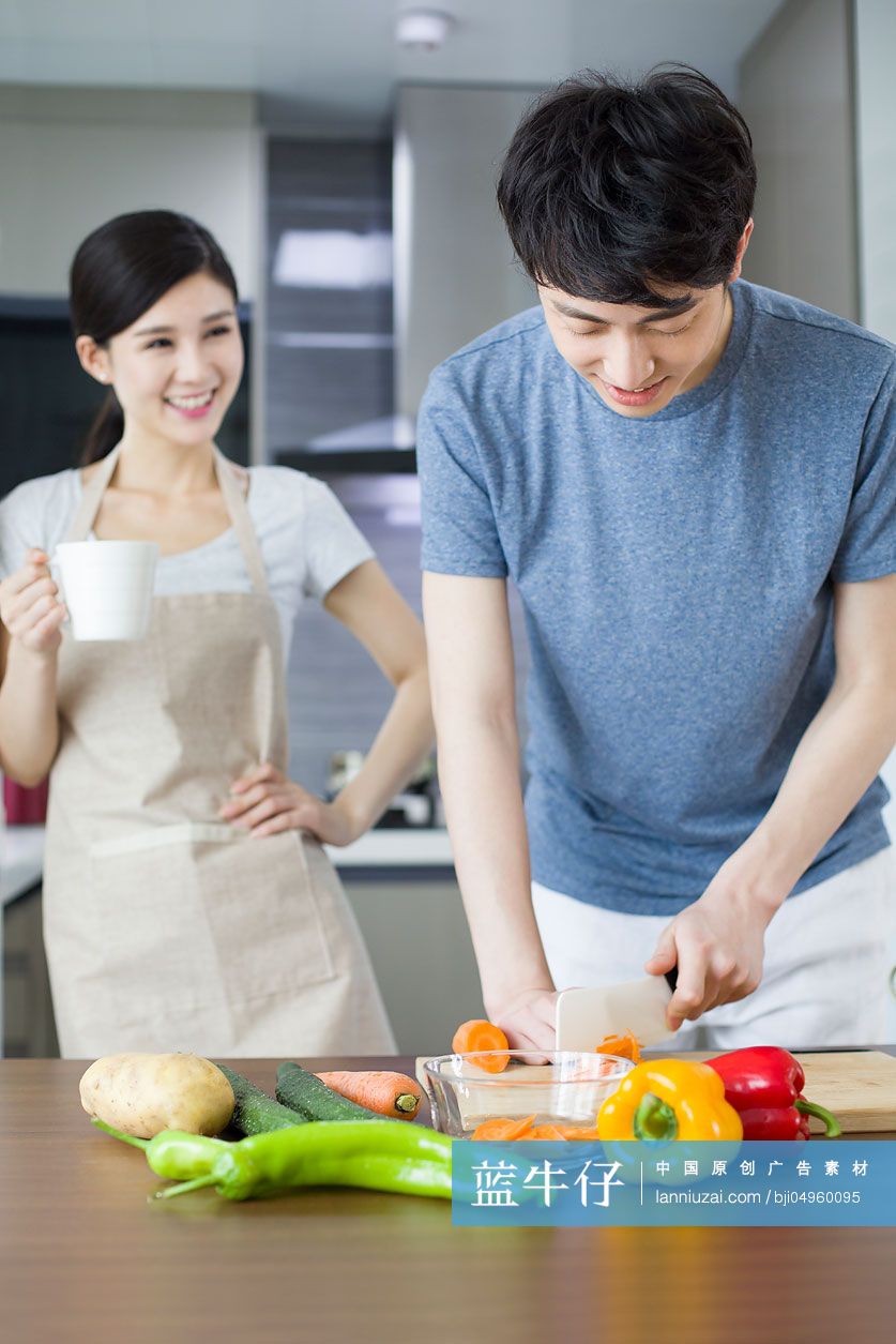 快乐的年轻夫妇在厨房做饭