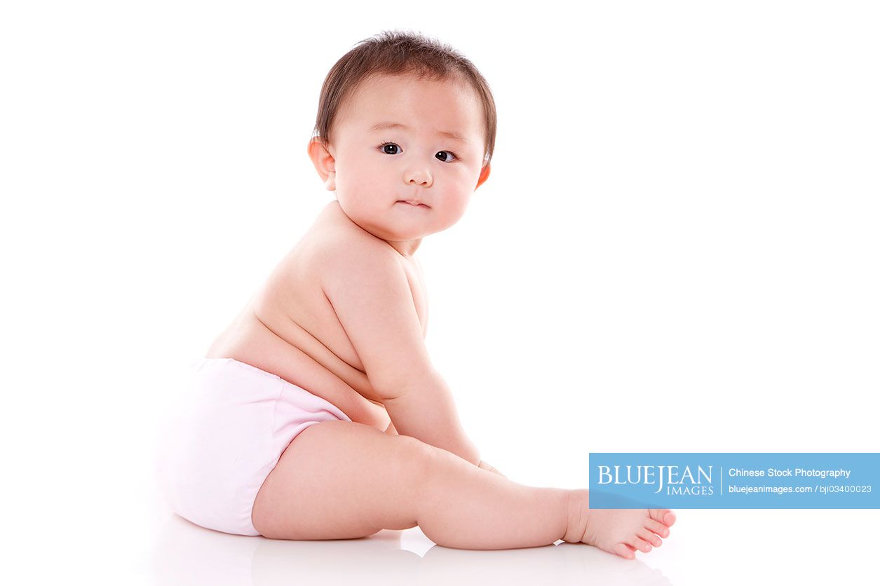 Portrait of cute Chinese baby girl looking over shoulder