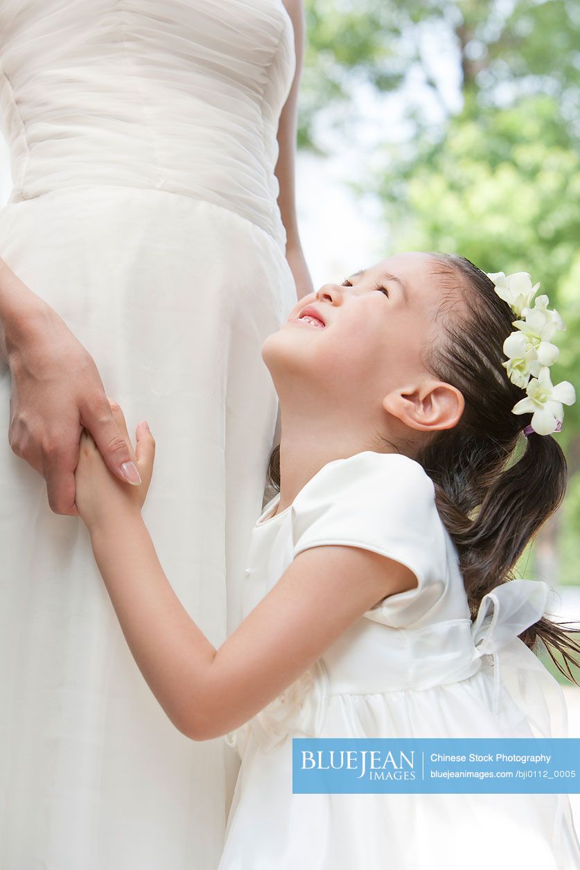 Young Chinese flower girl with the bride after a wedding