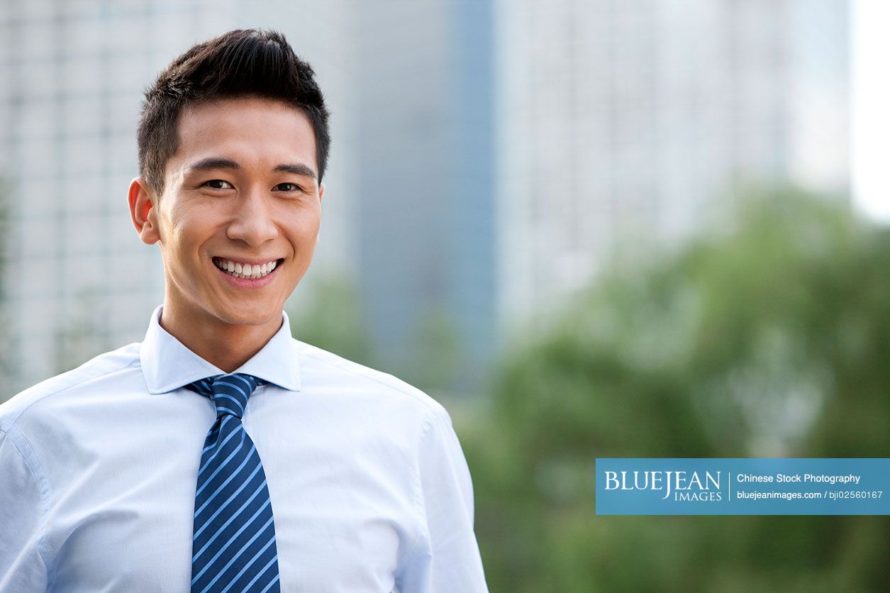 Confident Chinese businessman standing outdoors