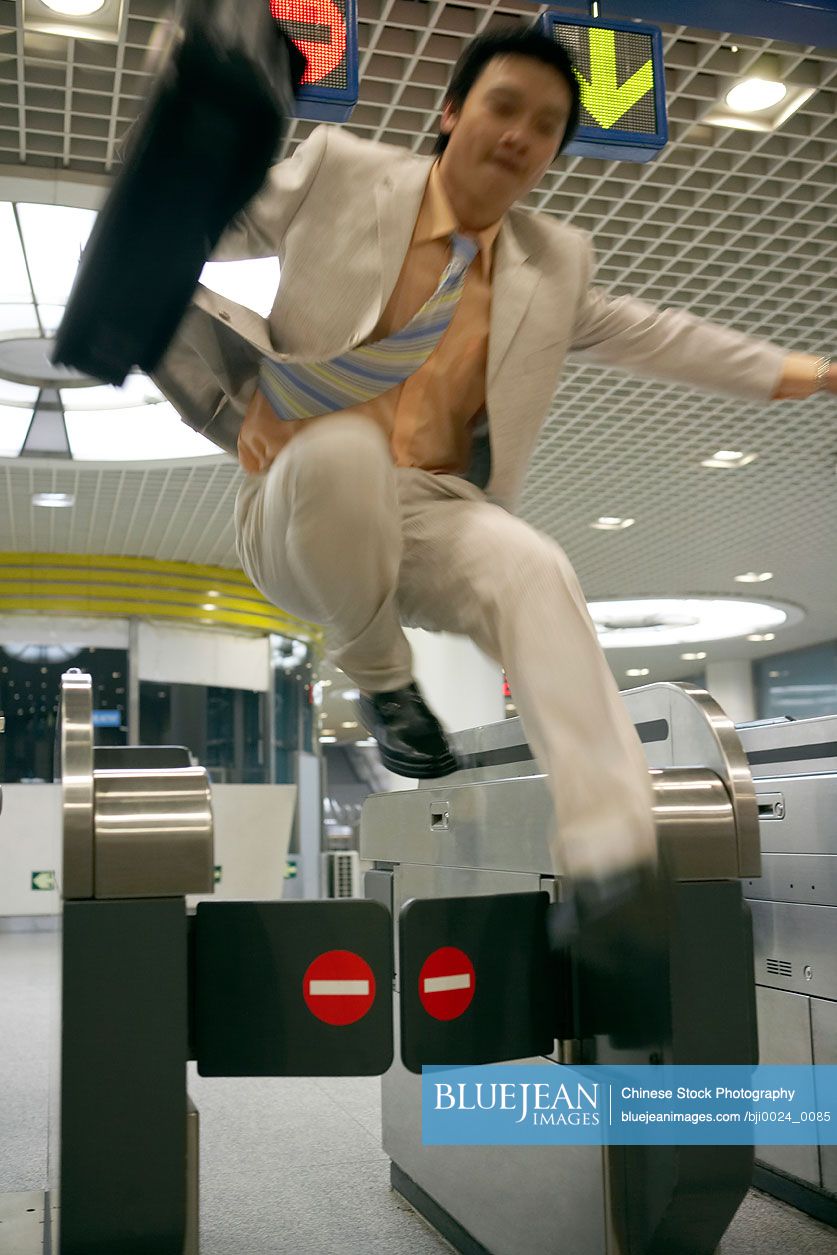 Chinese man jumping over a ticket gate at a subway station