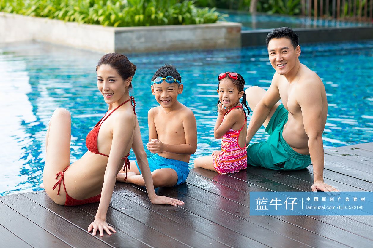 快乐的年轻家庭坐在泳池边戏水