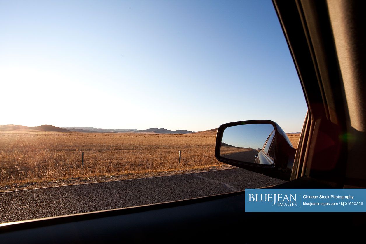 Car sideview mirror with road going through field in the background-High-res  stock photo for download