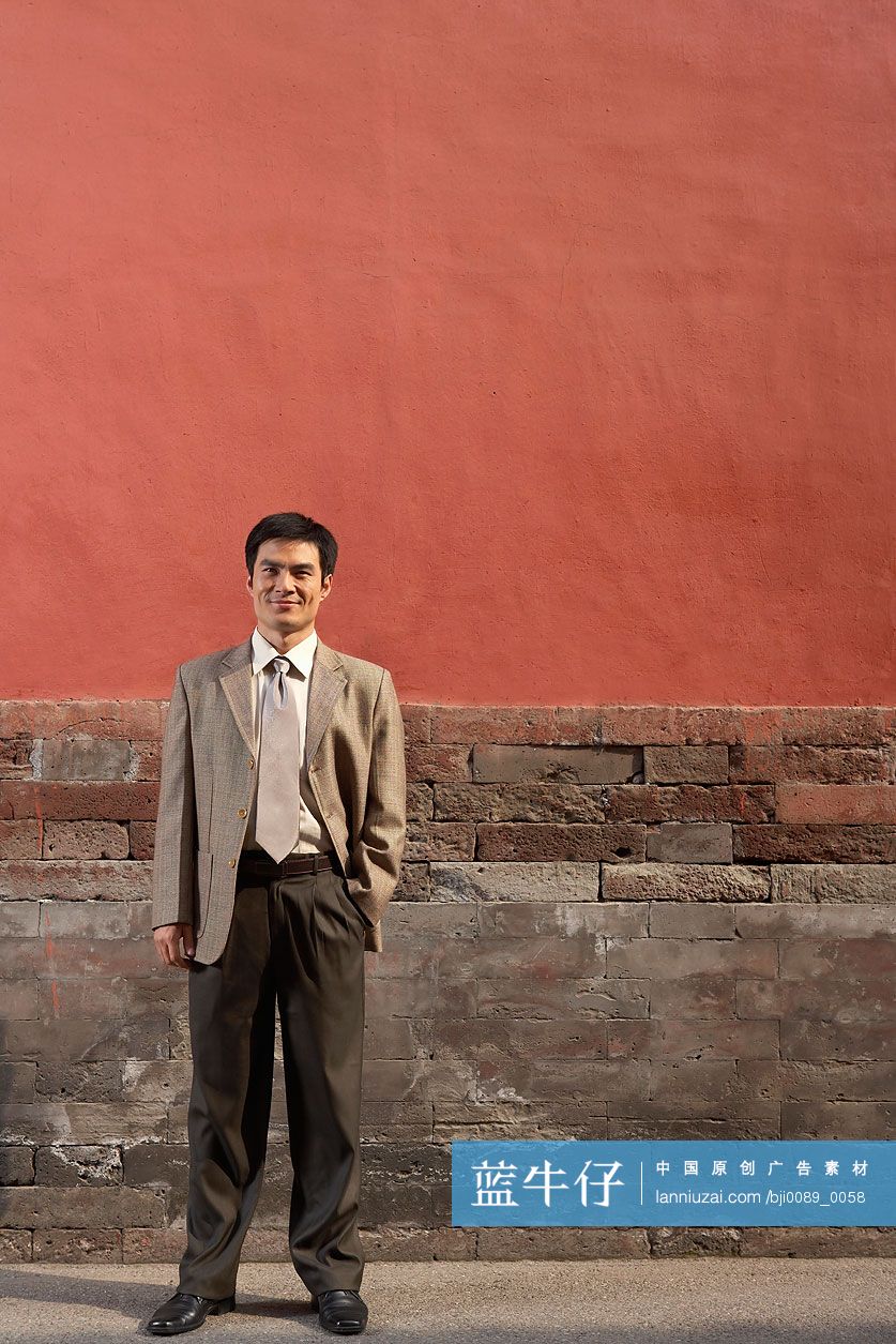 商务男士站在宫墙下