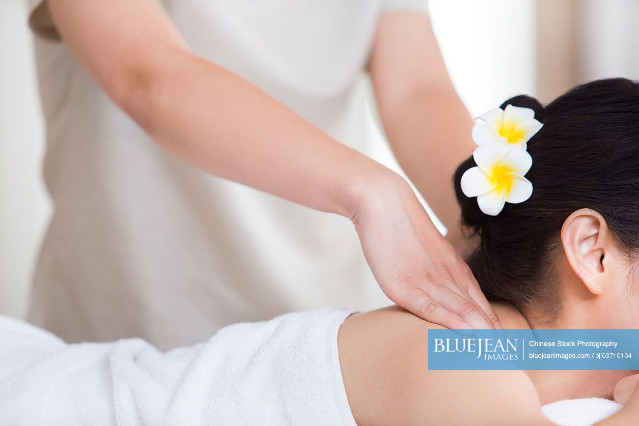 Young Chinese woman enjoying back massage