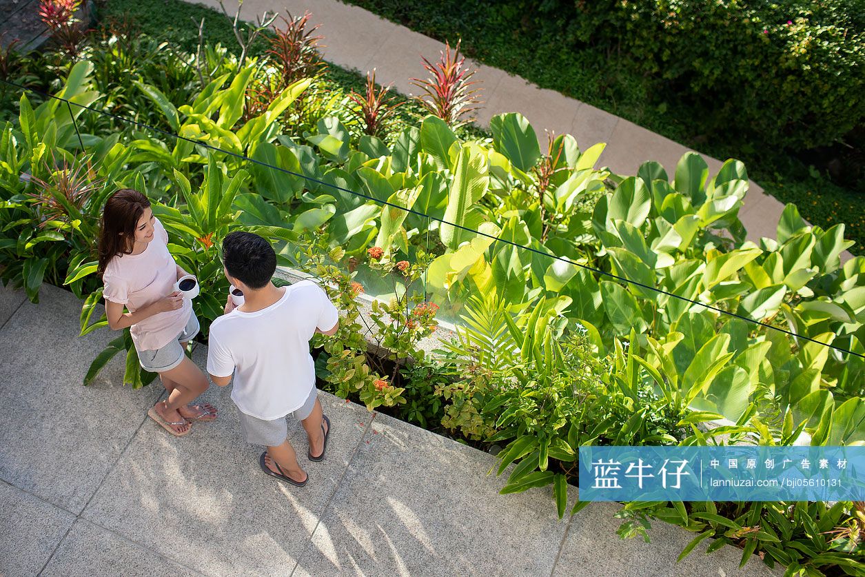 快乐的年轻夫妇在阳台喝咖啡