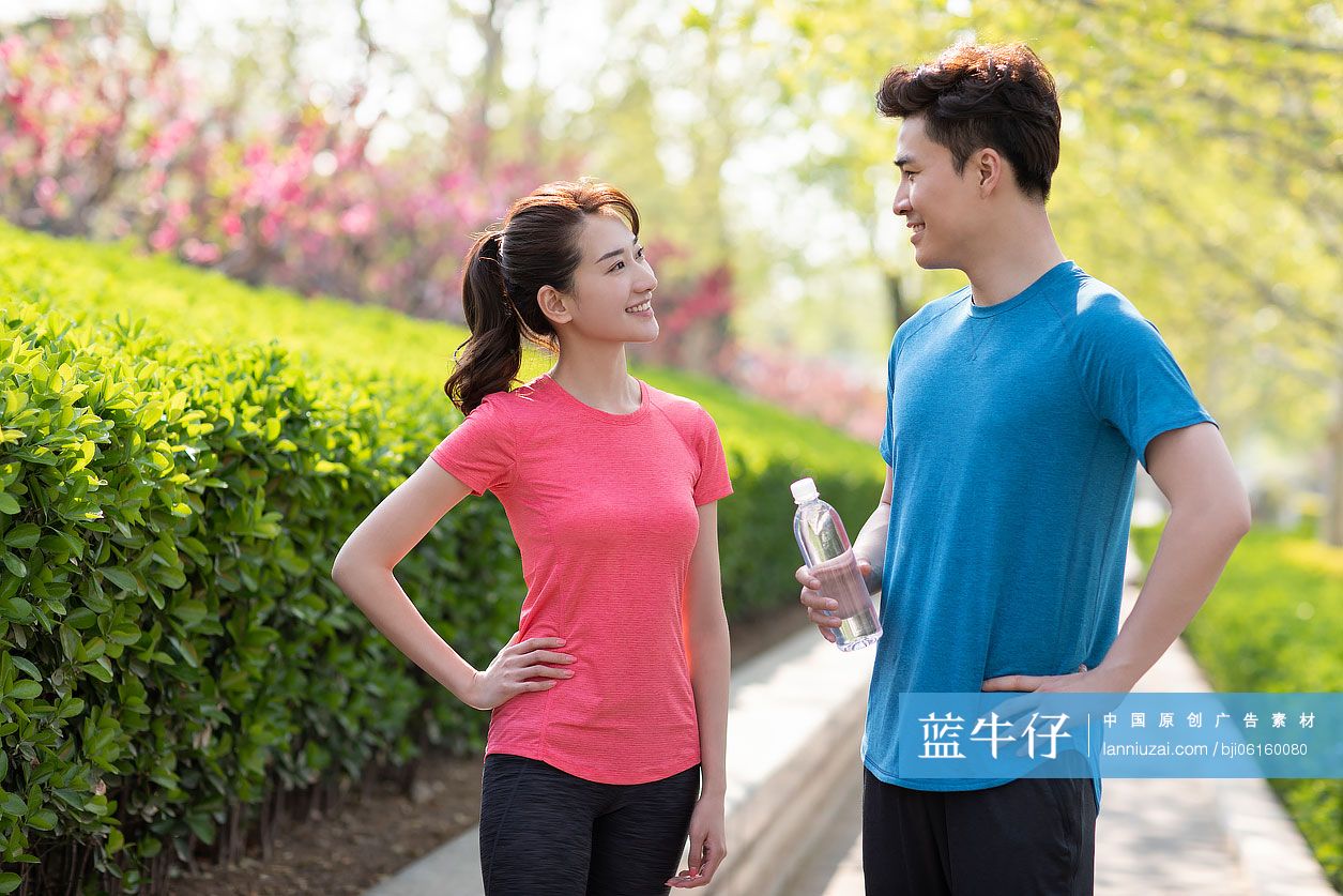 快乐的年轻情侣在公园健身后休息