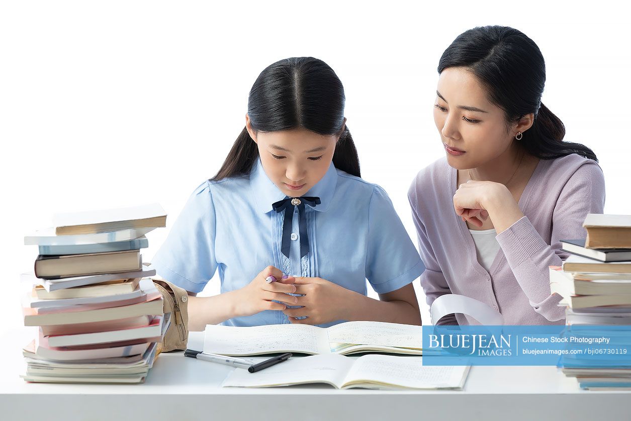Chinese mother helping her daughter with homework