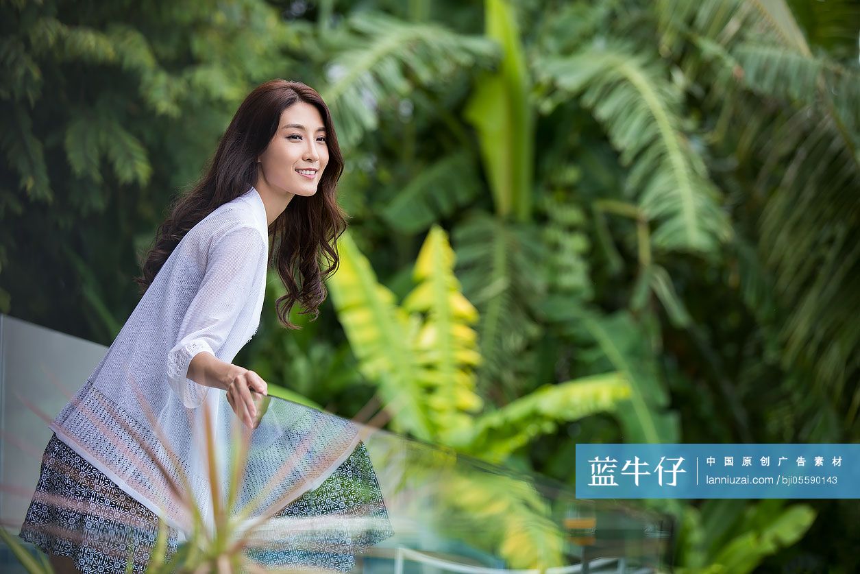 快乐的年轻女子在阳台上看风景