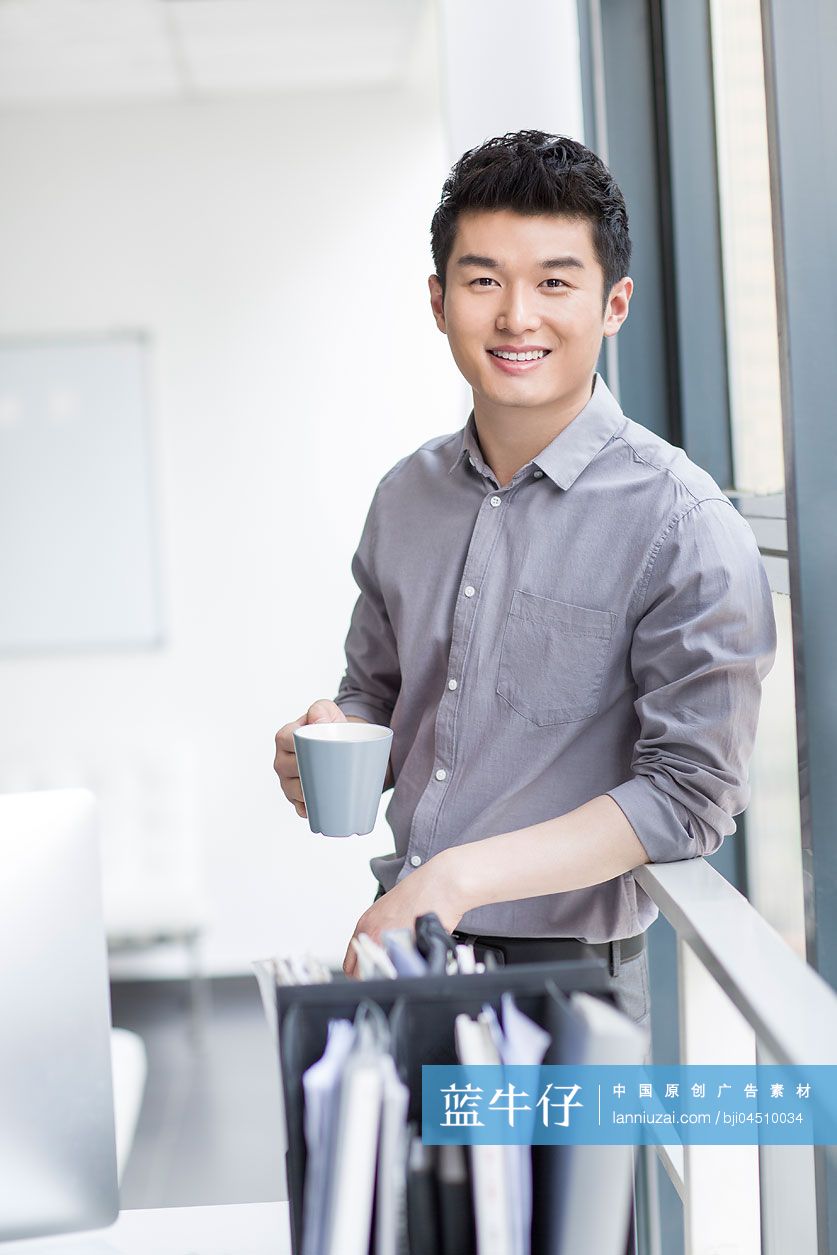 年轻商务男士在办公室喝咖啡