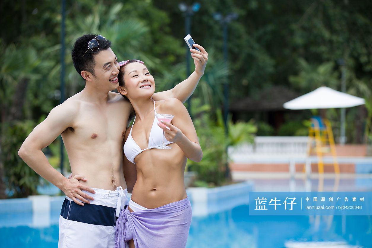 游泳池边拍照的年轻情侣