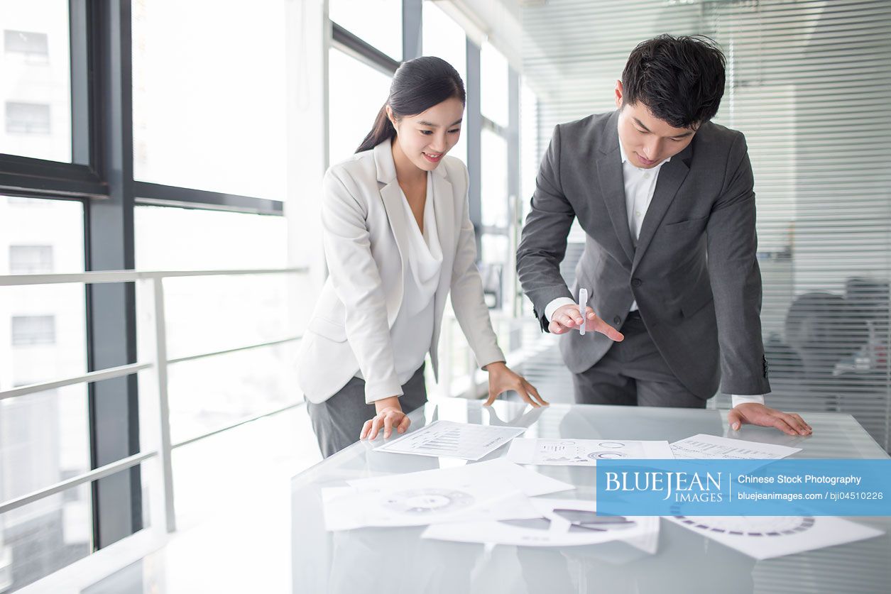 Young Chinese business person talking in meeting room