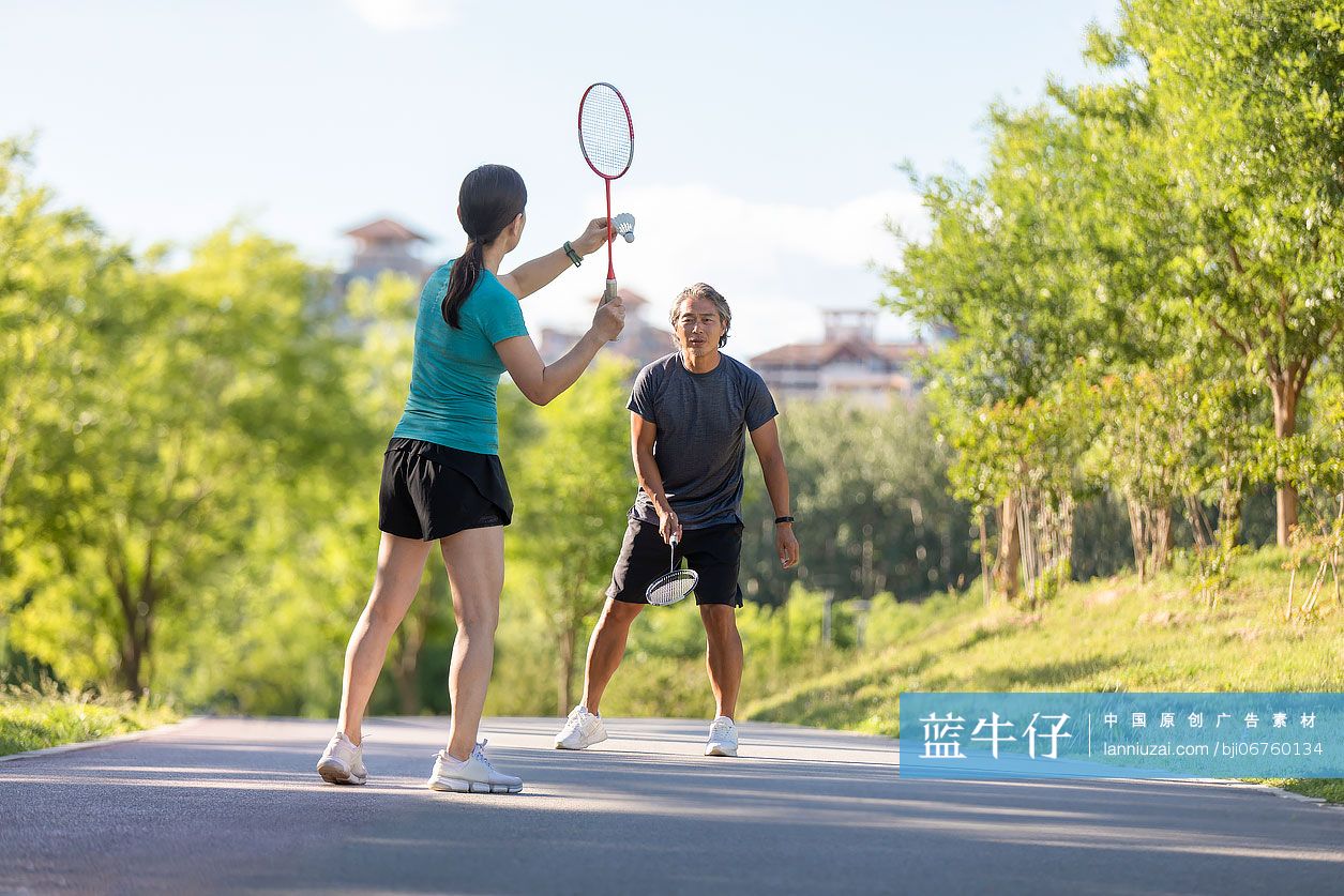开心的中老年夫妇在户外打羽毛球