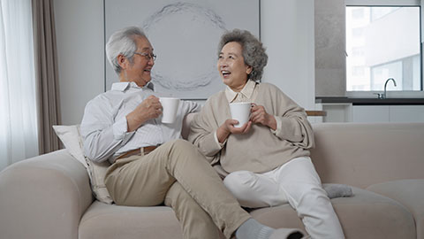 Cheerful senior Chinese couple drinking coffee at home,4K