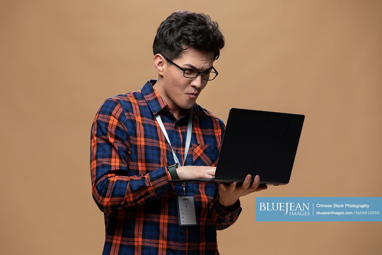 Young Chinese man working with laptop