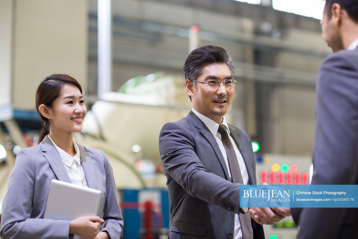 Business people shaking hands in the factory