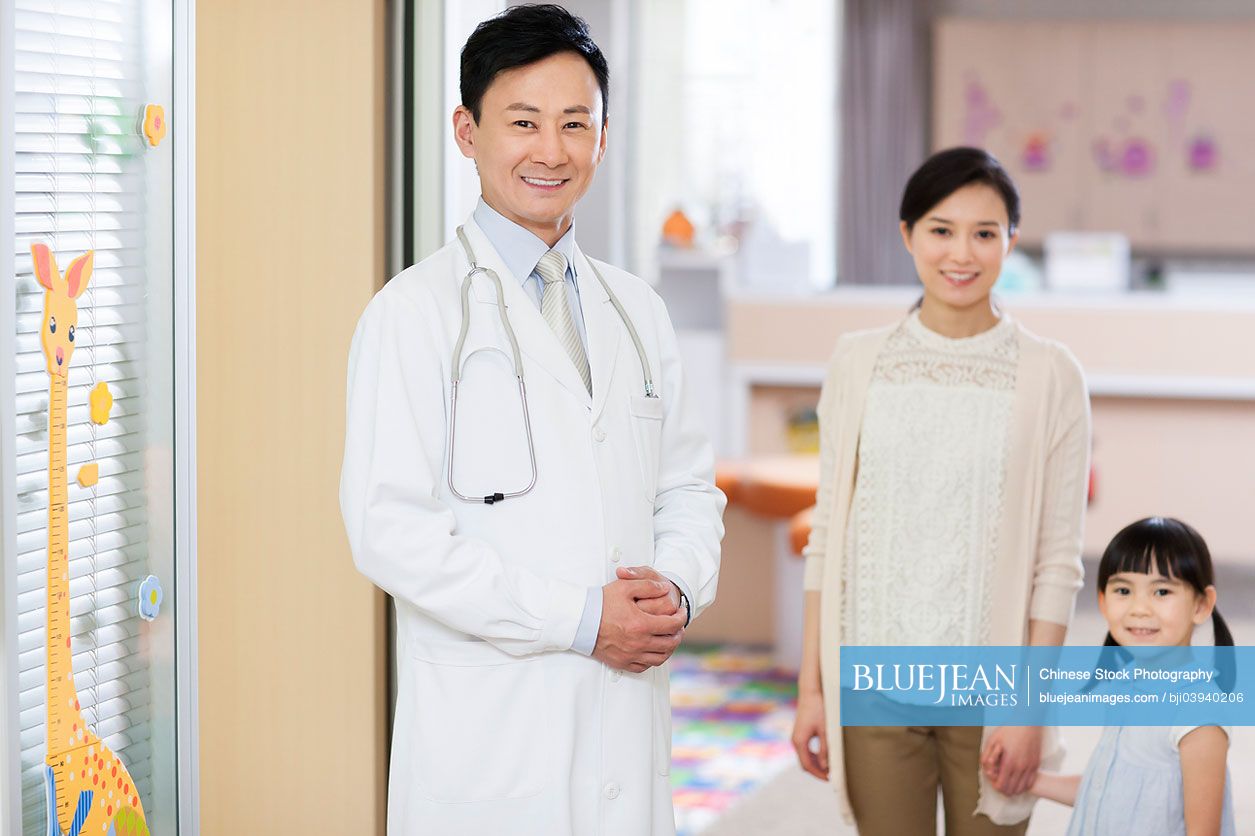 Chinese doctor with girl and young mother in children's hospital