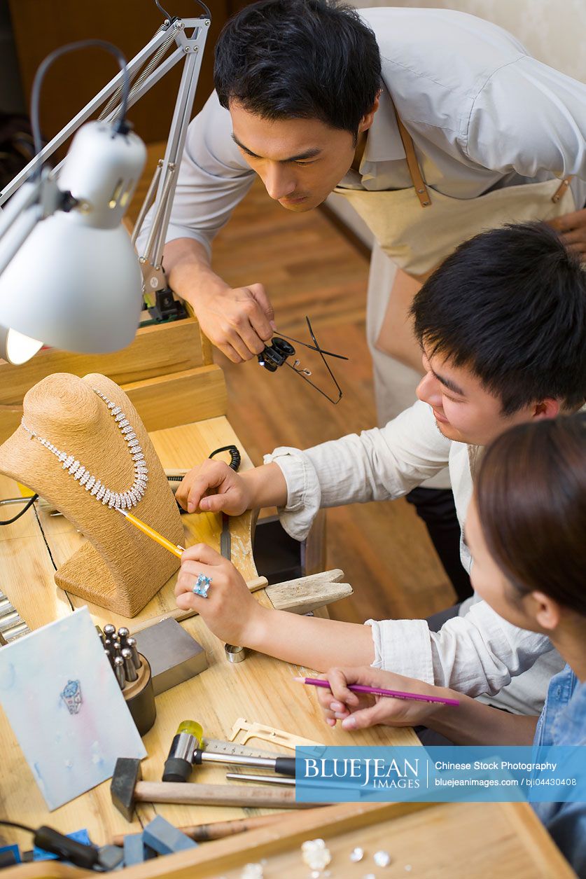 Chinese jewelers talking in studio