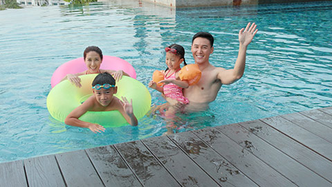 年轻家庭在泳池游泳