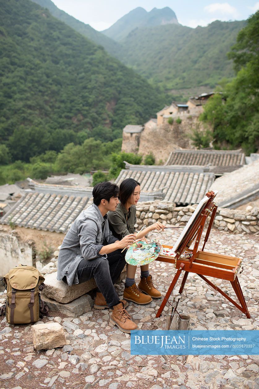 Young Chinese couple painting outdoors