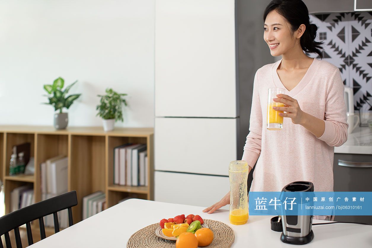 快乐年轻女士在家榨果汁