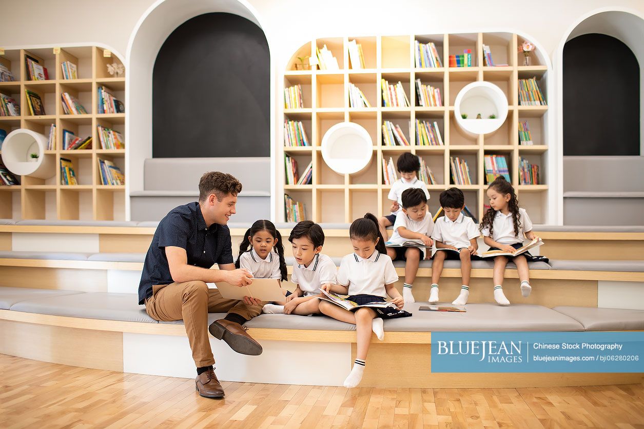 Children reading book in library