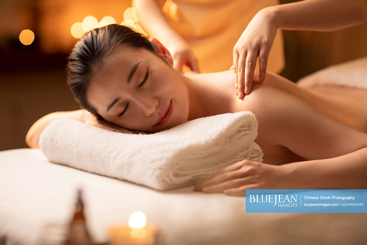 Young woman receiving a back massage in a spa center stock photo