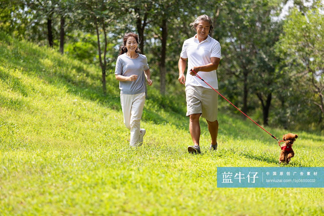 开心的中老年夫妇在公园遛狗