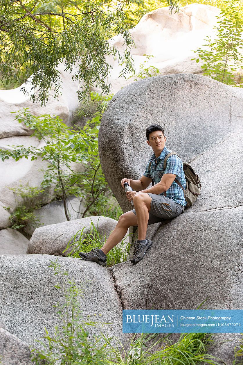 Young Chinese man hiking outdoors