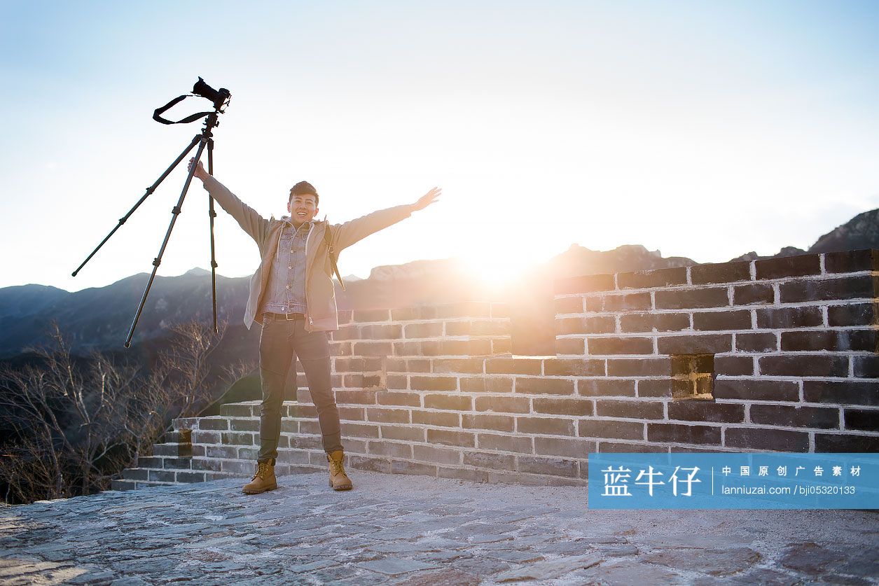 Happy young Chinese man photographing on the Great Wall