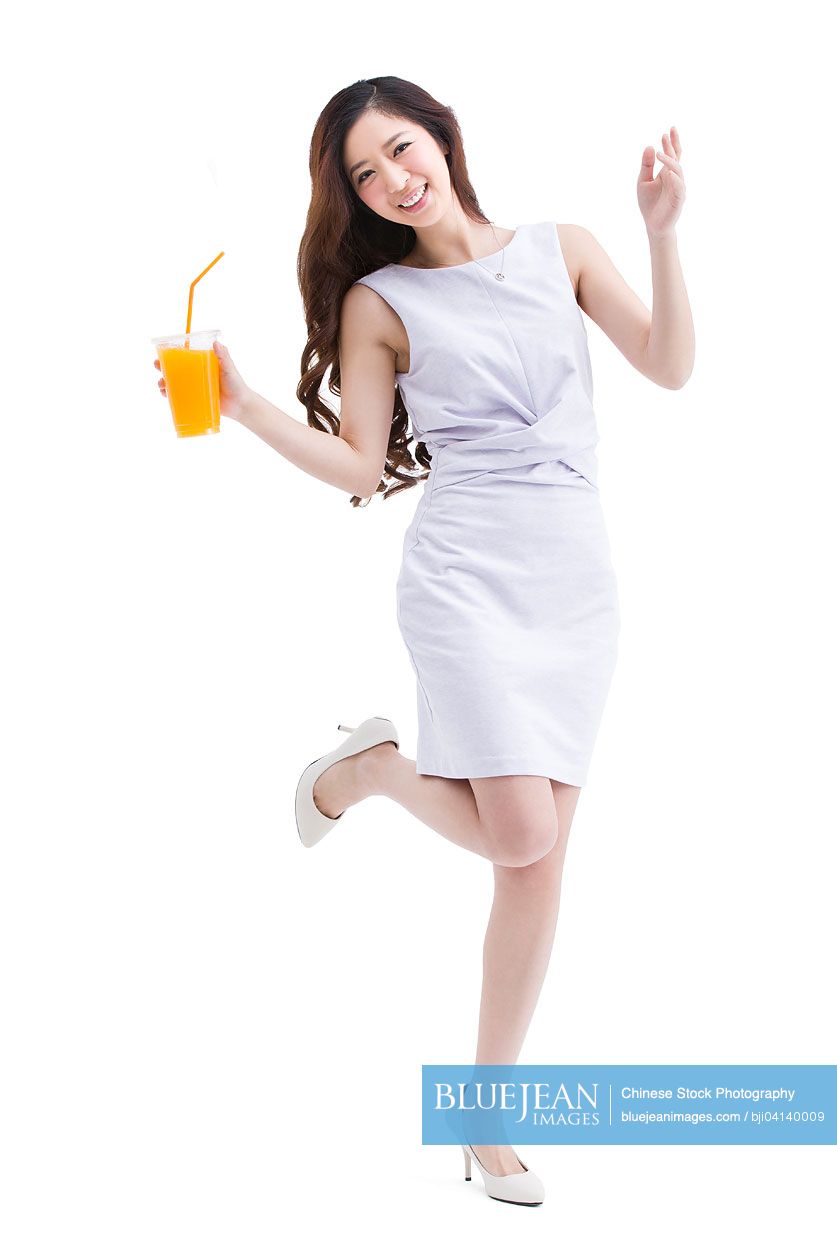 Portrait of beautiful young Chinese woman holding a cup of juice