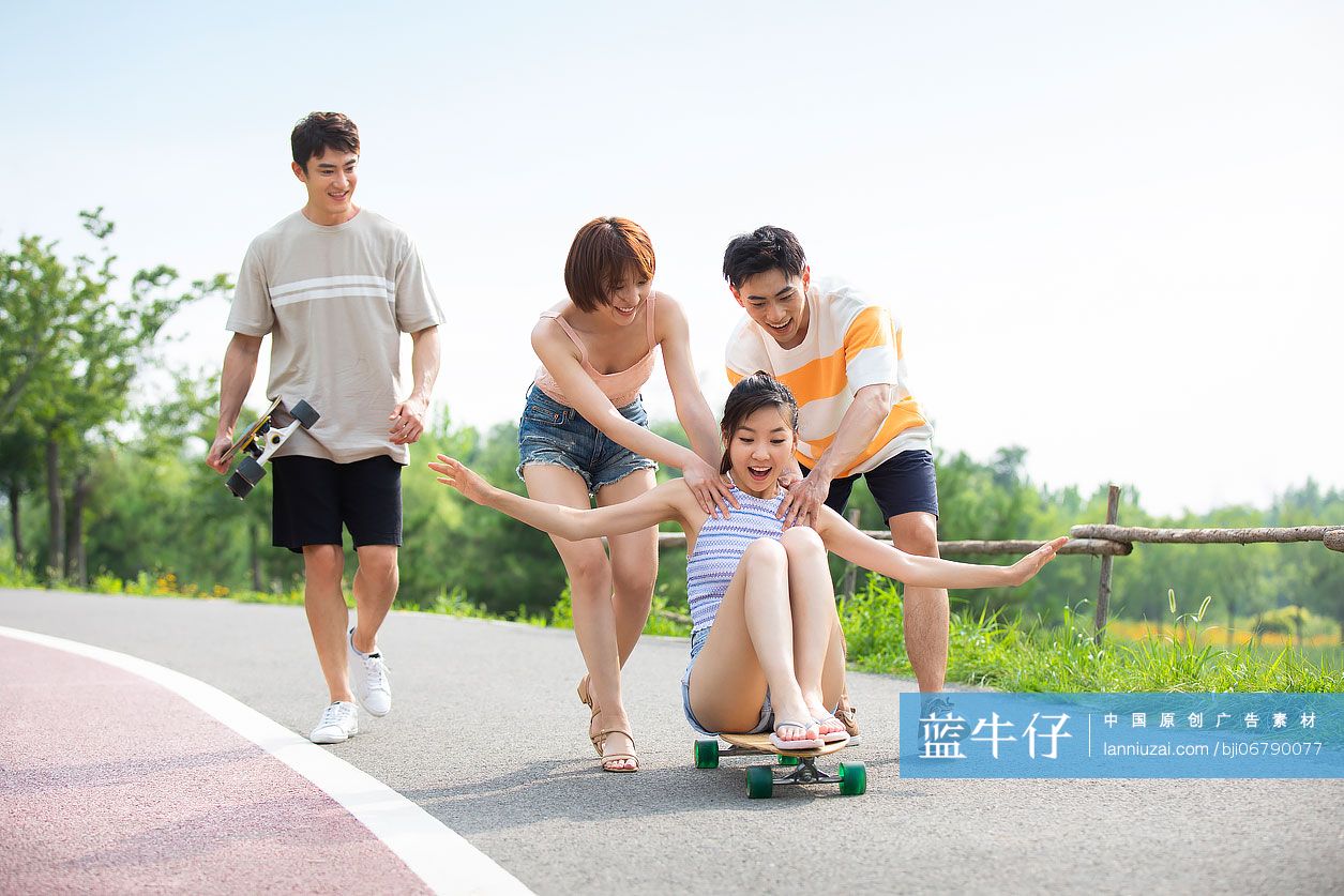 快乐的年轻人在公园玩滑板