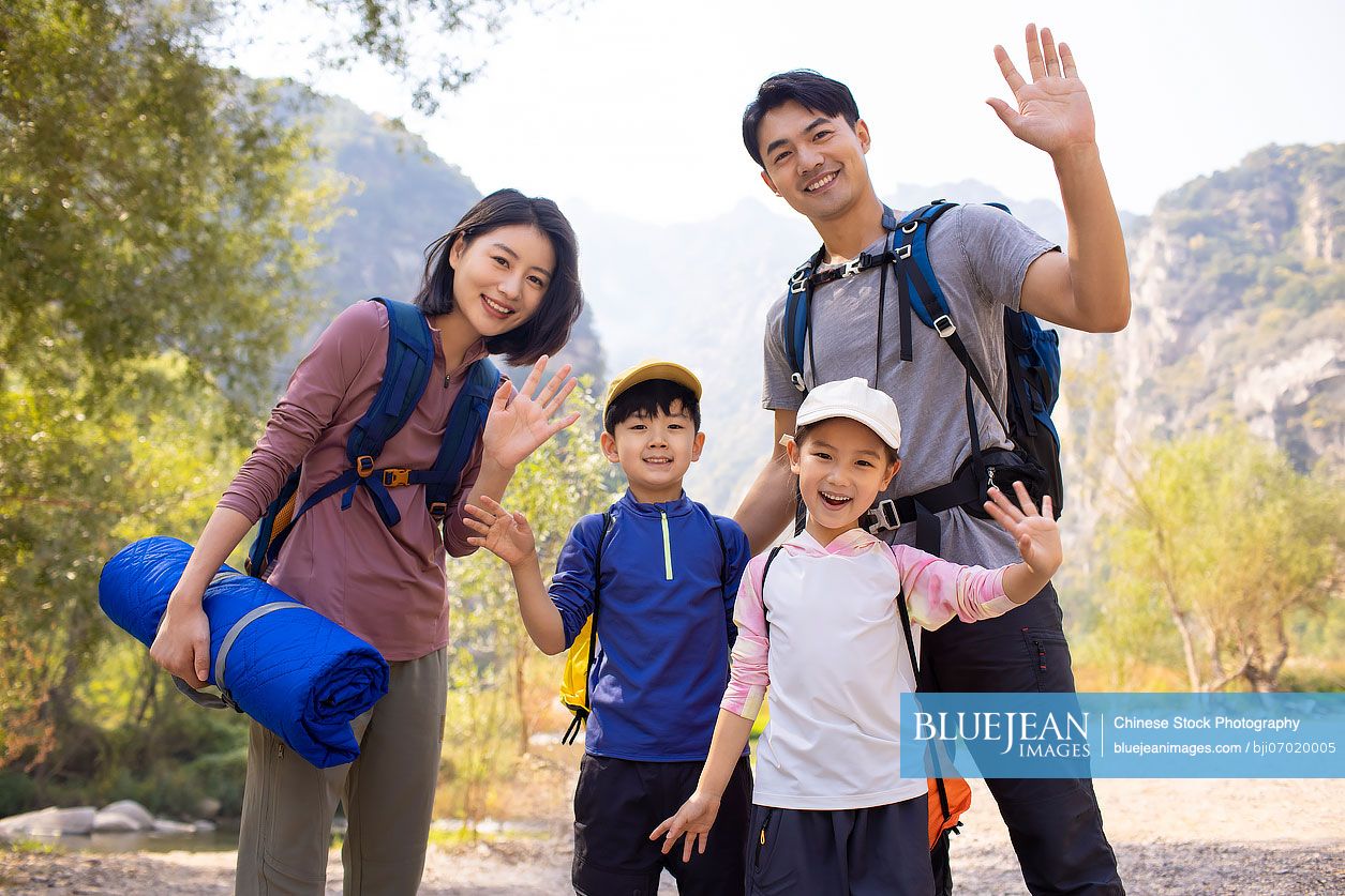 Happy young Chinese family hiking outdoors