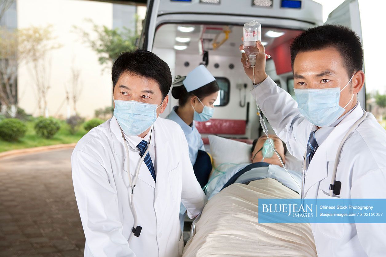 Chinese medics moving a patient from an ambulance
