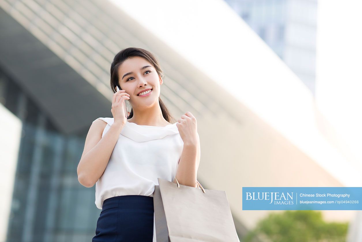 Happy young Chinese woman shopping