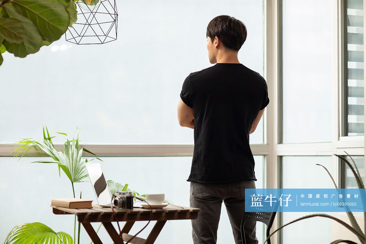 年轻摄影师看窗外