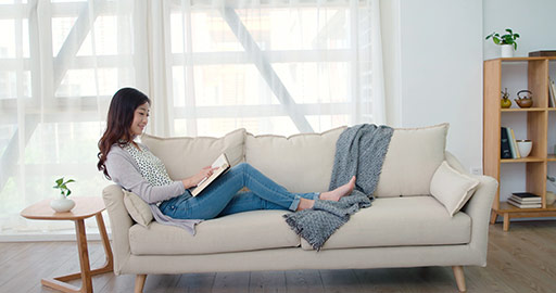 Happy young Chinese woman reading book in living room,4K