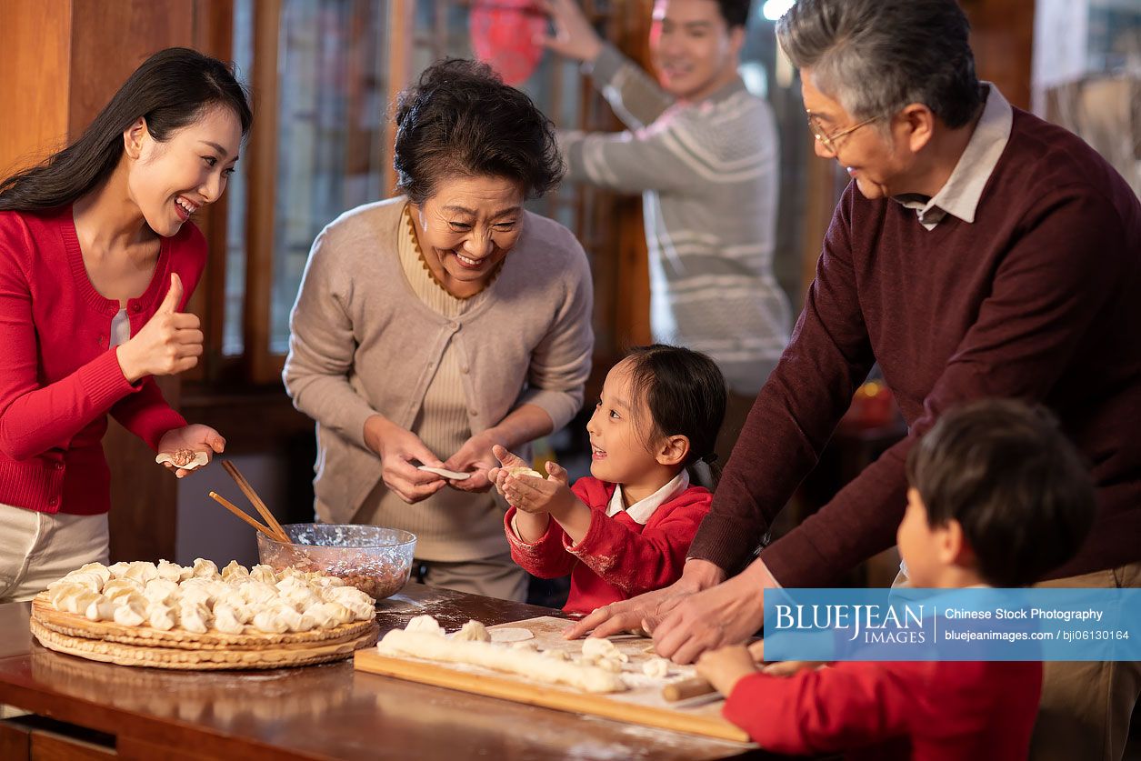 Happy Chinese family making dumplings