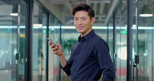 Confident Chinese businessman using smartphone in office,4K