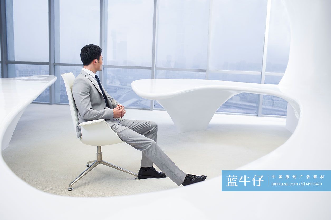 商务男士向办公室窗外望去