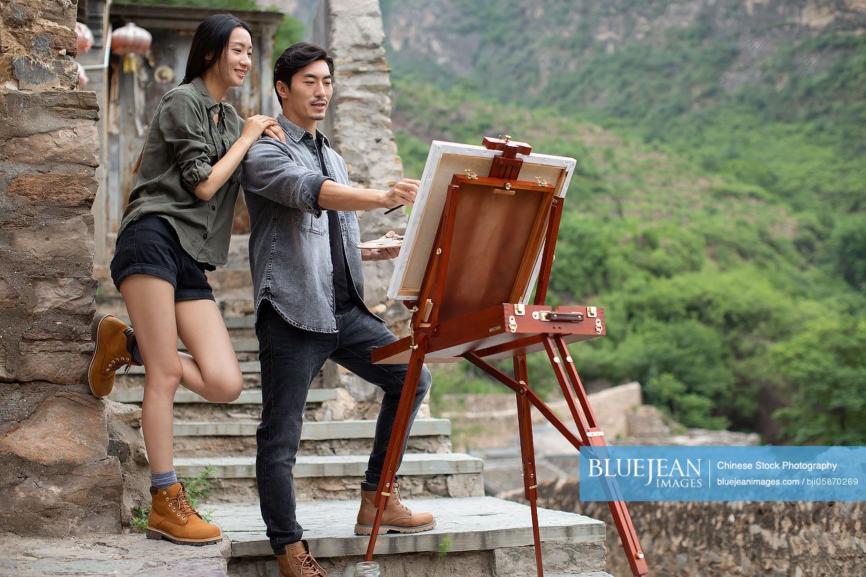 Young Chinese couple painting outdoors