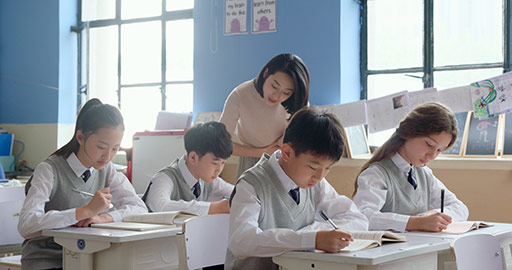 Young Chinese teacher helping students in classroom,4K