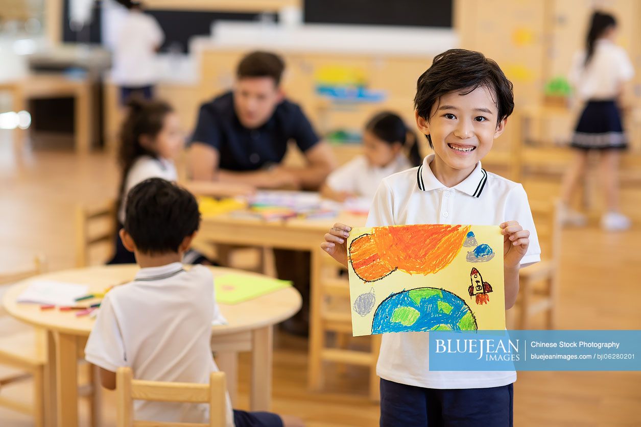 Little Chinese boy showing his painting