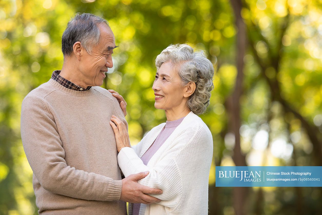 Cheerful senior Chinese couple dating in the park