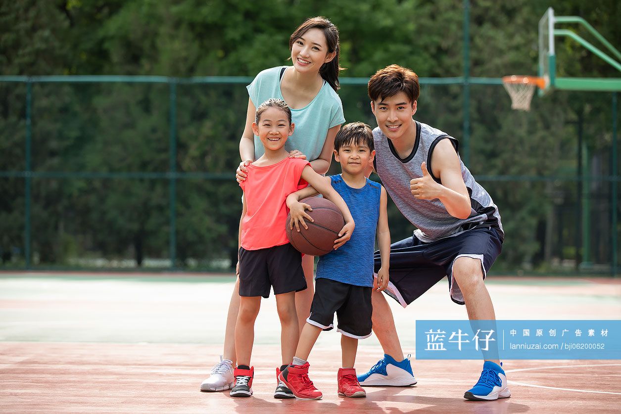 快乐的年轻家庭在篮球场打篮球