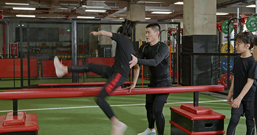 Active Chinese children having exercise class with their coach in gym,4K