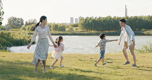 快乐的年轻家庭在草地上嬉戏