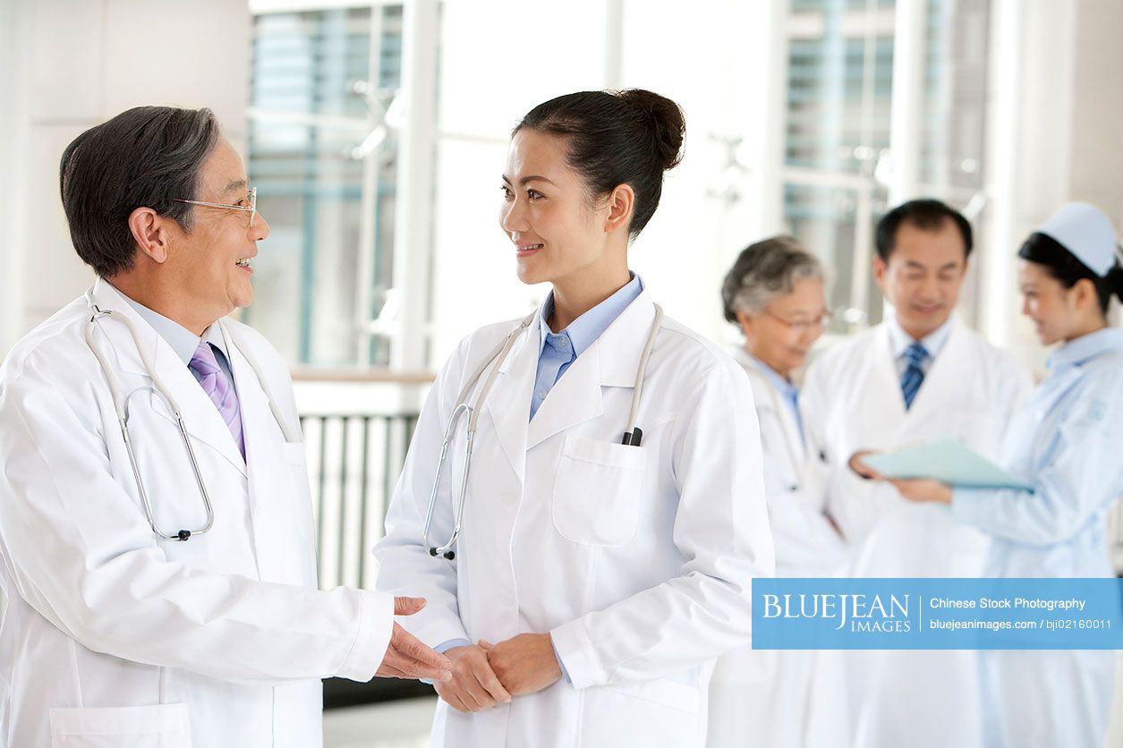 Chinese doctors and nurse in a hospital corridor in discussion