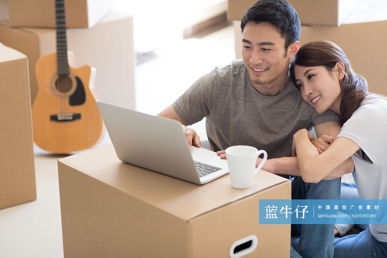 年轻夫妇在新房里使用笔记本电脑-蓝牛仔影像-中国原创广告影像素材