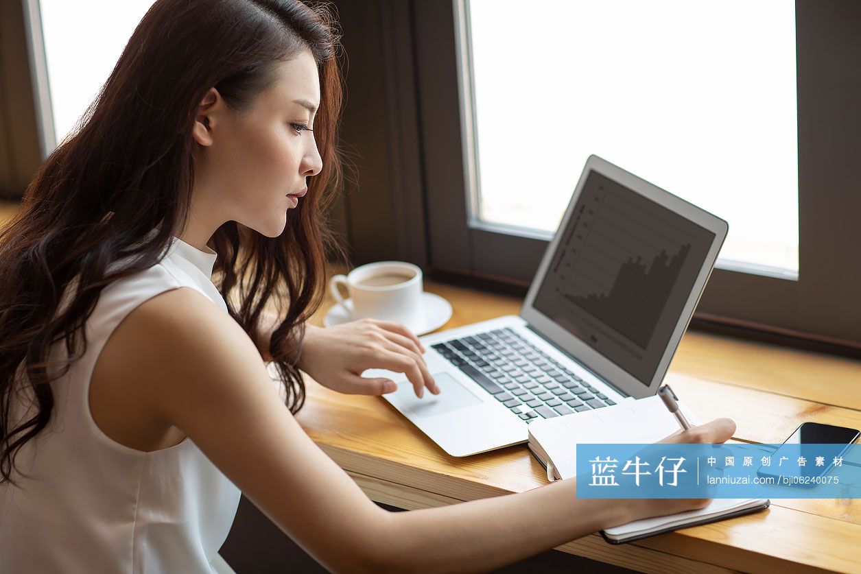 商务女士在咖啡馆使用笔记本电脑工作